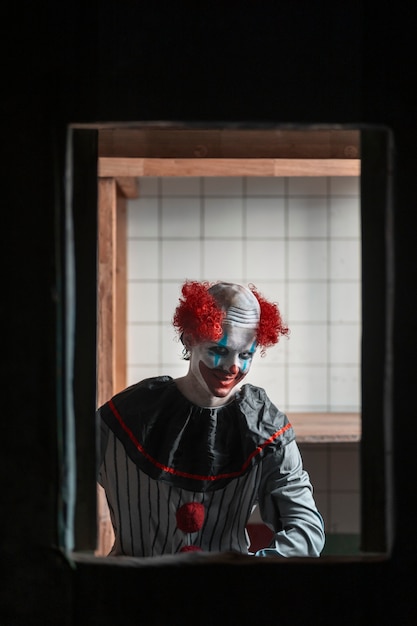 Kostenloses Foto gruseliger clown der vorderansicht in verlassenem gebäude