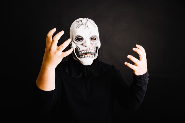 Gruseliger Mann posiert in Maske