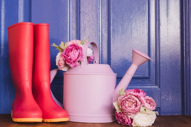 Kostenloses Foto gumboots, gießkanne und rosen