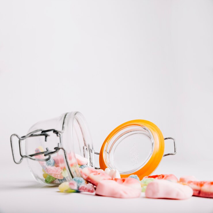 Kostenlose Foto gummy süßigkeiten fallen aus glas glas