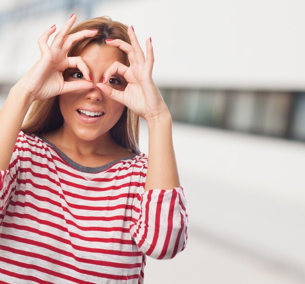 Gut aussehende Frau mit der Hand Fernglas