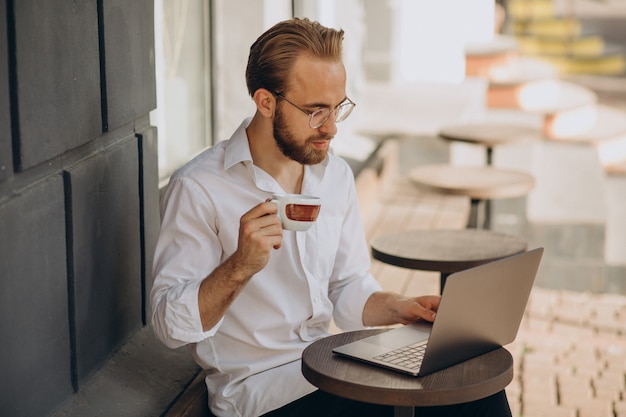 Gut aussehender Geschäftsmann, der online am Computer aus dem Café arbeitet?