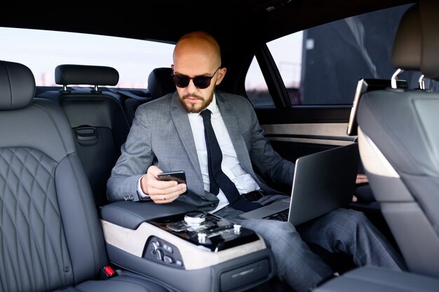Gut aussehender geschäftsmann, der sein mobiltelefon in einem modernen