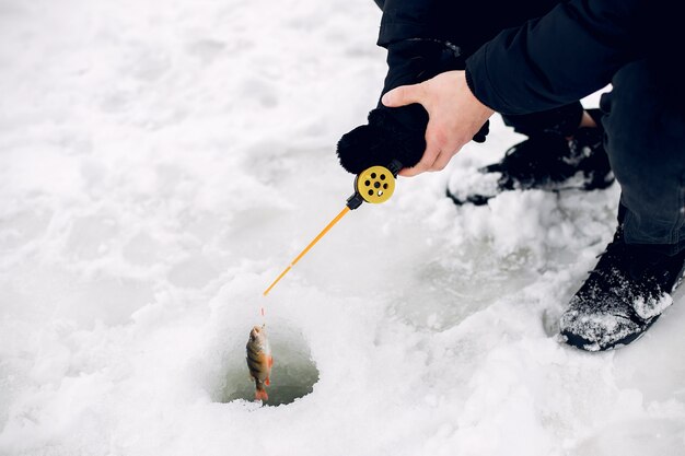 Gut aussehender Mann auf einem Winterfischen