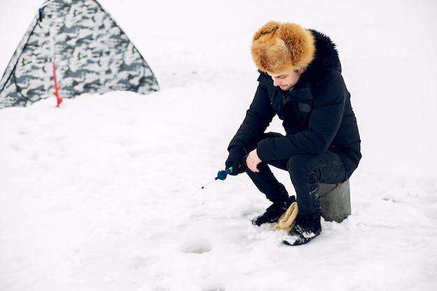 Kostenloses Foto gut aussehender mann auf einem winterfischen