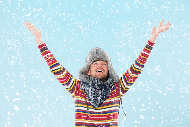 Gut aussehender Mann, der am Schnee zujubelt