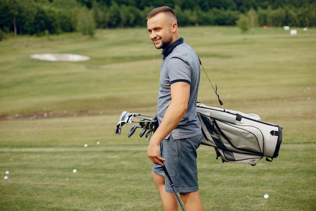 Gut aussehender Mann, der Golf auf einem Golfplatz spielt