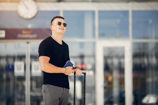 Gut aussehender Mann, der im Flughafen steht