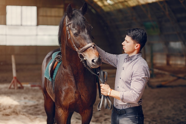 Gut aussehender Mann, der in einer Ranch steht