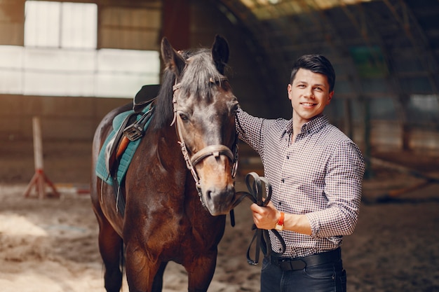 Gut aussehender Mann, der in einer Ranch steht