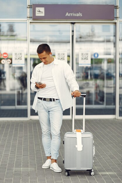 Gut aussehender Mann, der nahe dem Flughafen steht