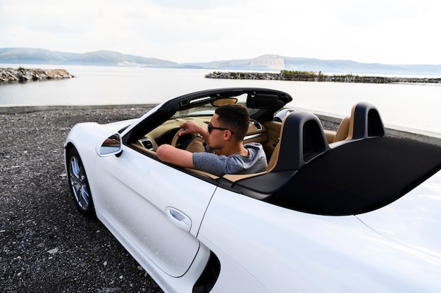 Kostenloses Foto gut aussehender mann im weißen auto