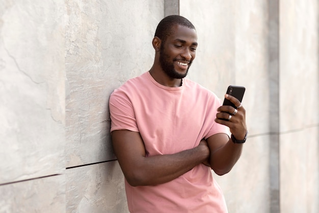 Gut aussehender Mann mit modernem Smartphone im Freien