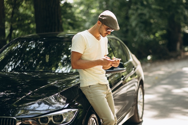 Gut aussehender Mann mit Telefon mit dem Auto