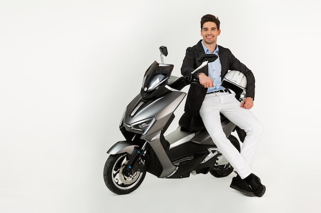 Gutaussehender Mann, der auf elektrischem Motorradroller reitet, isoliert auf weißem Studiohintergrund
