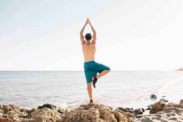 Guy macht Balance Übung am Strand