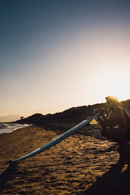 Kostenloses Foto guy mit surfbrett am strand