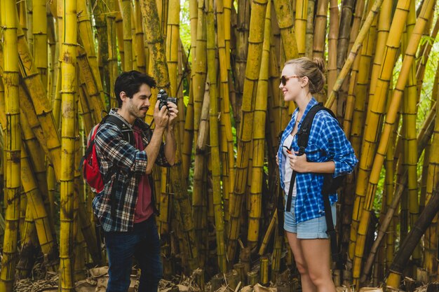 Guy nimmt Foto von Freundin in Bambuswald