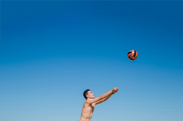 Guy schlägt Volleyball