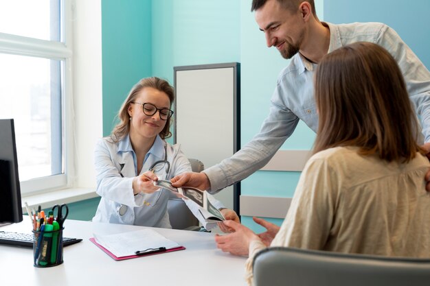 Gynäkologe, der die Schwangerschaft mit der Patientin bewertet