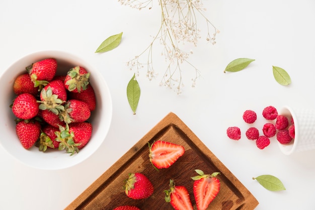 Gypsophila Blumen und Blätter mit Erdbeeren und Himbeeren isoliert auf weißem Hintergrund