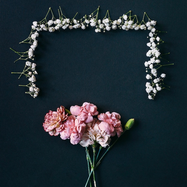 Gypsophila- und Gartennelkenblumen mit der Knospe vereinbarten auf schwarzem Hintergrund