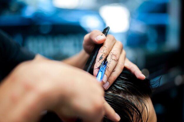 Haarschnitt mit der unscharfen Hand des Friseurs