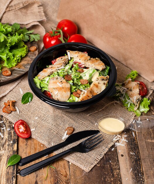 Hähnchen-Caesar-Salat mit gehacktem Parmesan, Tomate, Salat, Cracker.