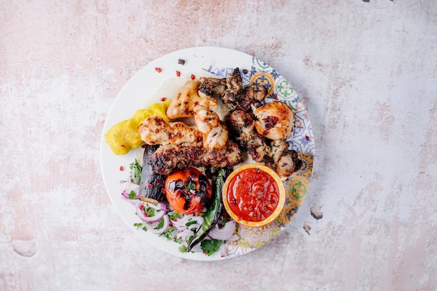 Hähnchen-Kebab mit gegrilltem Gemüse und Barbecque-Sauce.