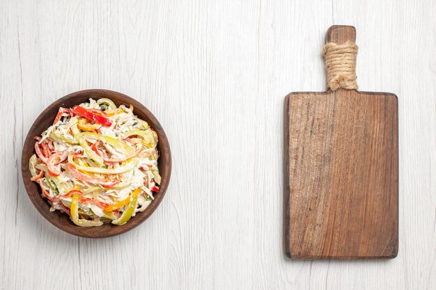 Hähnchensalat von oben mit Mayyonise und geschnittenem Gemüse im Teller auf hellweißem Schreibtisch frische Salatfleisch-Snack-Mahlzeit