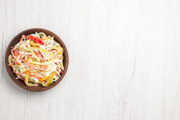 Hähnchensalat von oben mit Mayyonise und geschnittenem Gemüse im Teller auf weißem Schreibtisch frische Salatfleisch-Snackmahlzeit