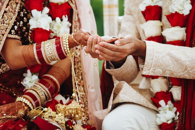 Hände der indischen Braut und des Bräutigams verflochten zusammen, authentisches Hochzeitsritual machend