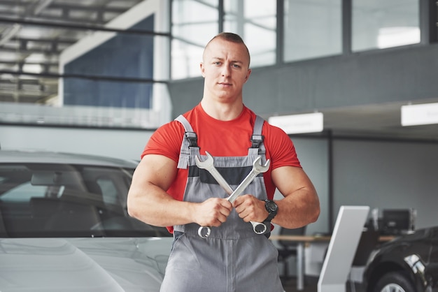 Hände des Automechanikers mit Schraubenschlüssel in der Garage.