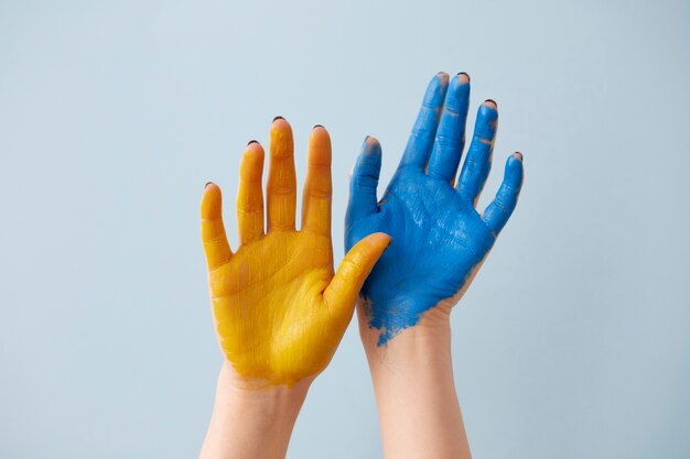 Hände, die die ukrainische Flagge darstellen