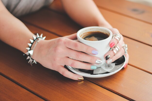 Hände, die eine Tasse Kaffee