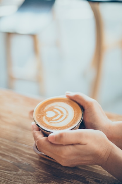 Hände, die eine Tasse Kaffee