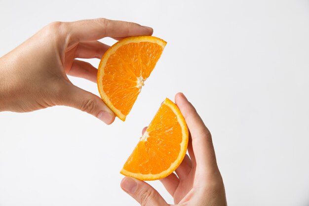Hände, die geschnittene orangefarbene Abschnitte verbinden
