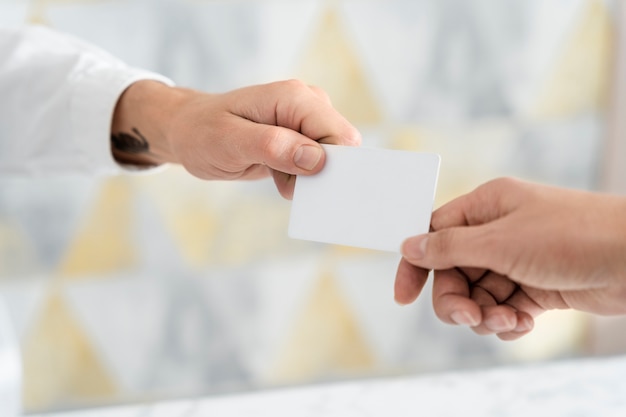 Hände, die leere Visitenkarte im Büro halten