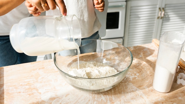 Kostenloses Foto hände, die milch in eine schüssel gießen