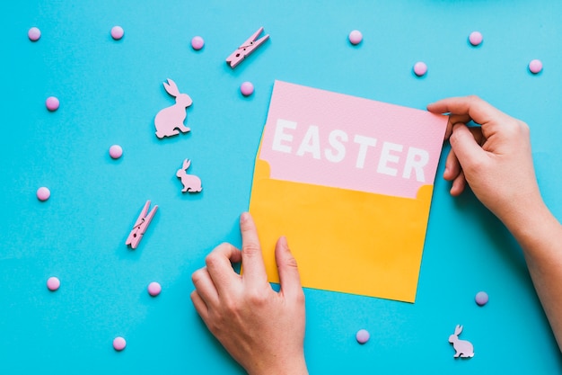 Kostenloses Foto hände, die ostern-wort vom umschlag nehmen