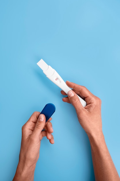 Hände, die positiven Schwangerschaftstest halten