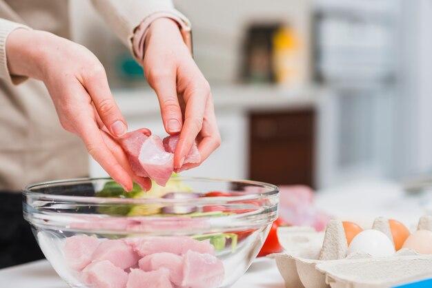 Hände, die Stücke Fleisch halten