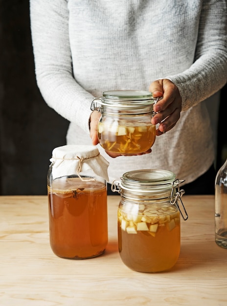 Kostenloses Foto hände, die vorderansicht des kombucha-glases halten