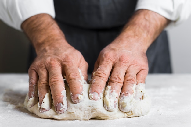 Hände gefüllt mit Teig für Brot