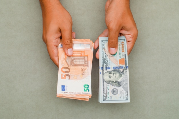 Hände halten Dollar und Euro.