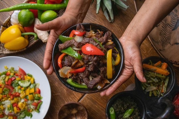 Hände halten eine Schüssel Fajita, mexikanisches Essen