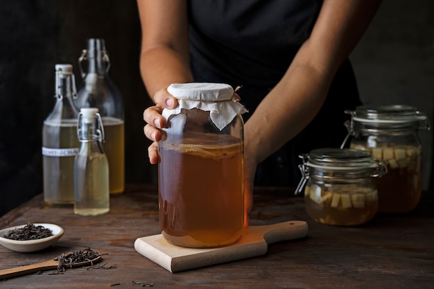 Kostenloses Foto hände halten kombucha-glas-seitenansicht