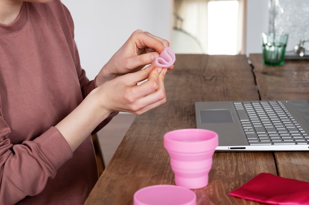 Hände halten Menstruationstasse Seitenansicht