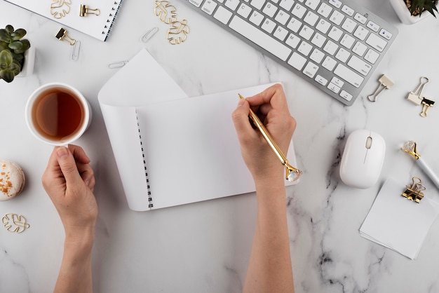 Hände halten Stift und Tasse nah oben