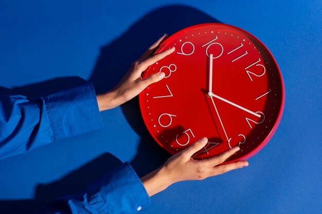 Hände halten Stillleben mit einer Wanduhr